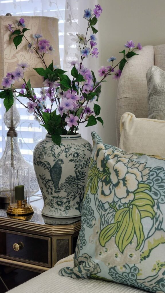 Green and white ginger jar on bedroom night stand with flowers in the jar