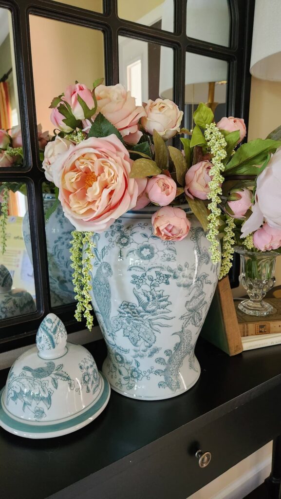 green and white ginger jar with pink peonies in it