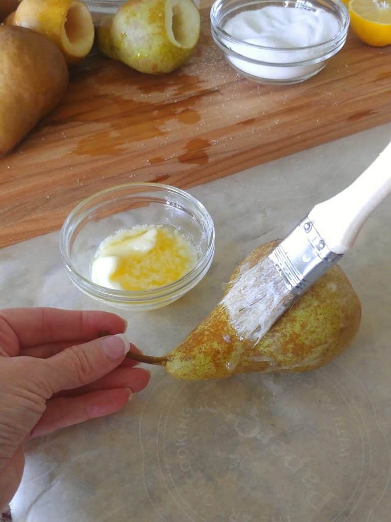 brushing pear with butter on outside of pear