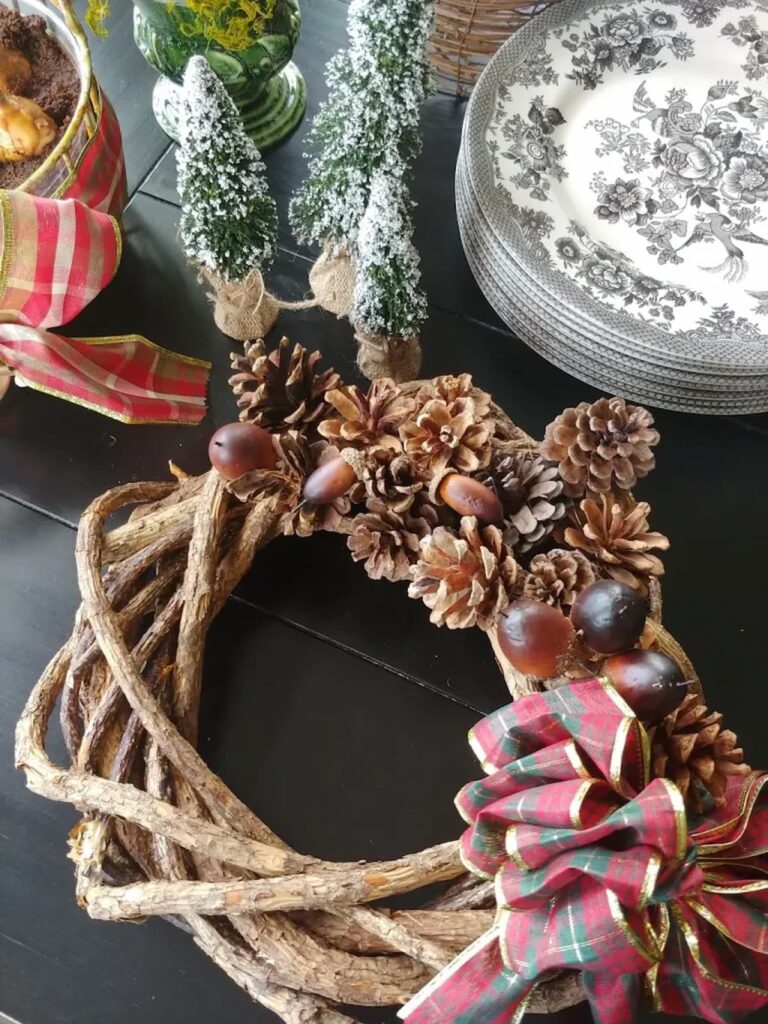 grapevine wreath with pinecones and ribbon on it