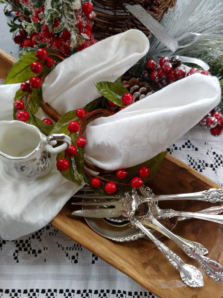 a wooden dough bowl with silver utensils in it