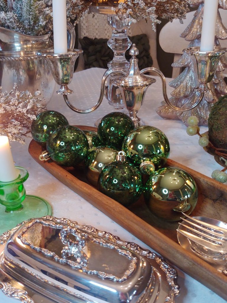 a wooden dough bowl with green ornaments in it