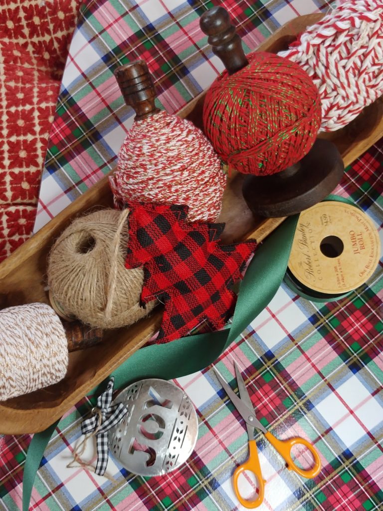 A dough bowl with spool of yard in it