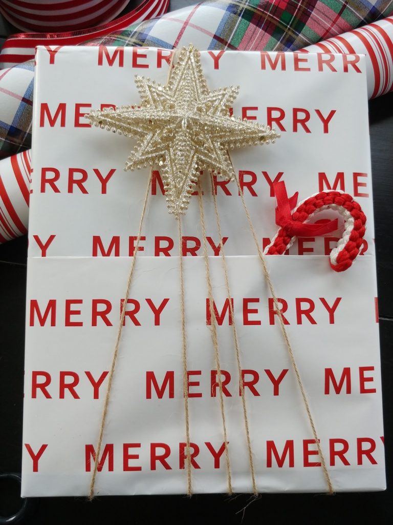present wrapped with christmas star and candycane on top