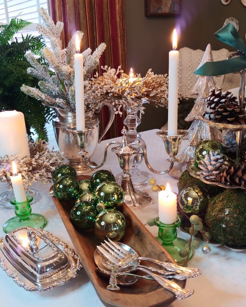 silver candle holder and silver pieces on a table