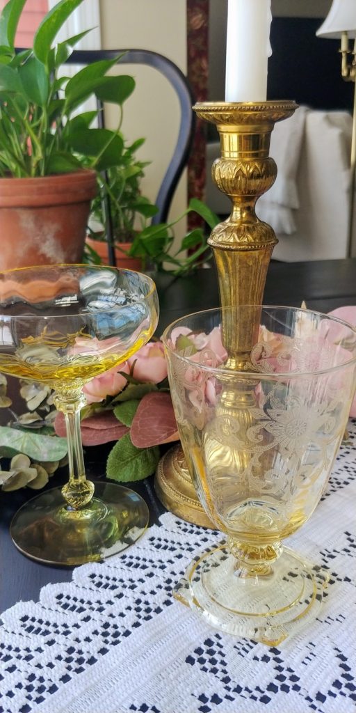 A glass candlestick on a table, with Champagne Flute
