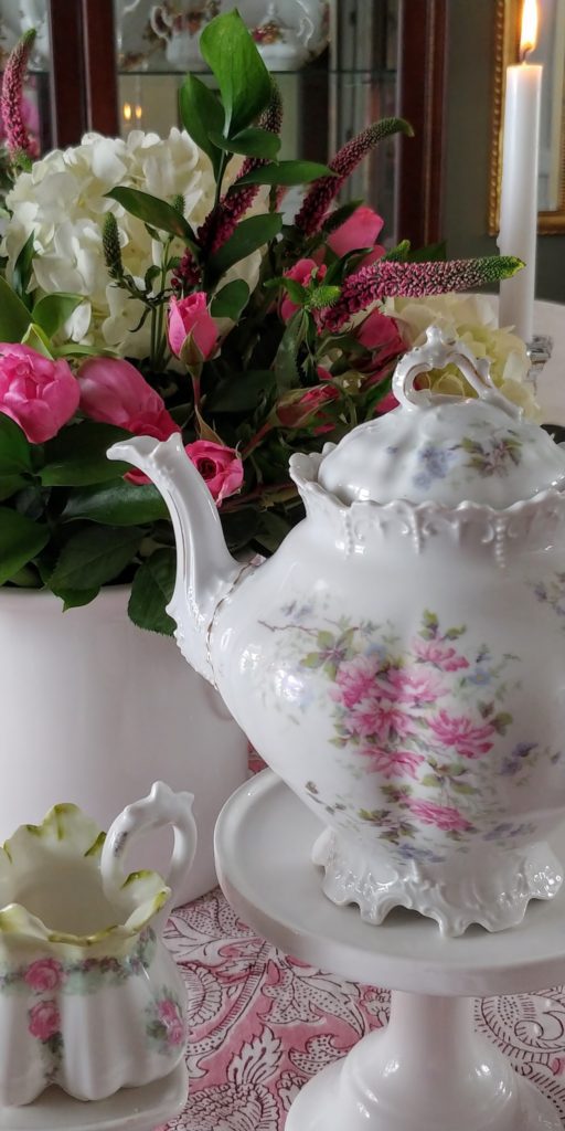 A close up of a flower vase and teapot on a table