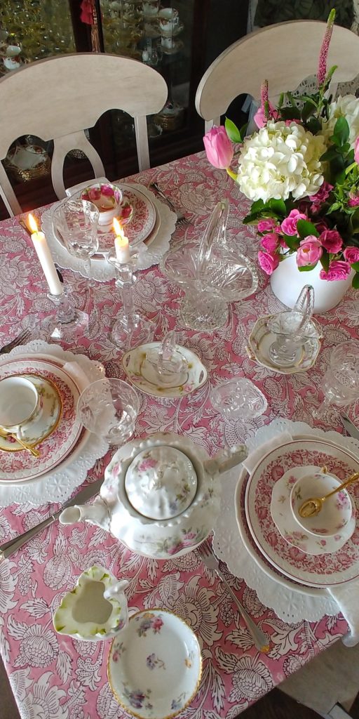A bunch of pink dishes  with teacups 