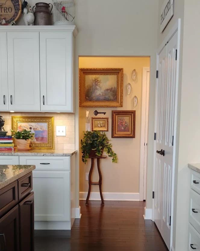view into hallway with a gallery wall of paintings on it