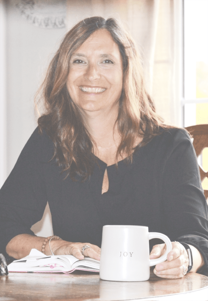 A woman sitting at a table with a cup of coffee