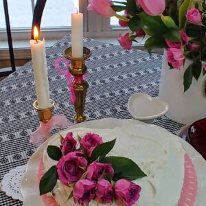 A heart-shaped cake with pink flowers on a table
