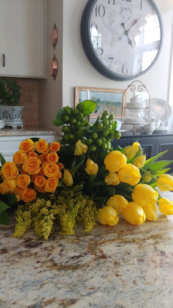A bouquet of yellow flowers on a countertop