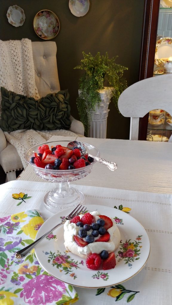 A table topped with plates of food on a plate, with Pavlova and Berry