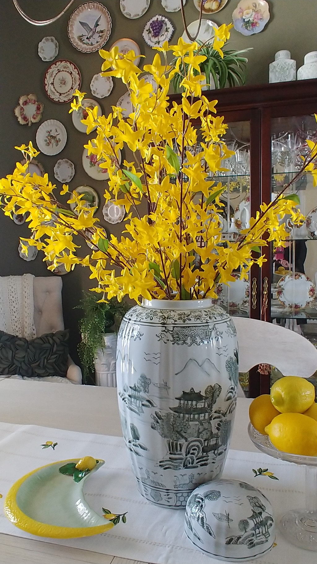 A vase of yellow forsythia flowers on a table