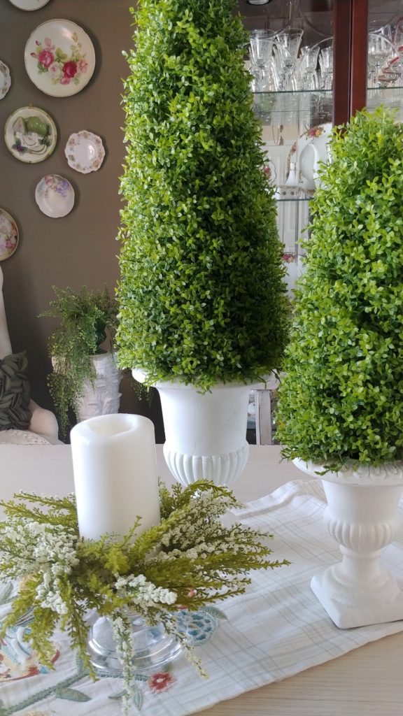 A candle and greenery on a table