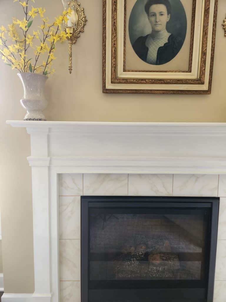 A fire place mantle in a living room with a fireplace