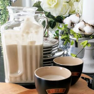 homemade irish creme in glass decanter with two cups next to it