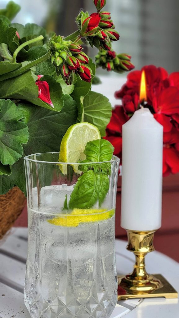 Water glass with sliced lemons and a candle on a table