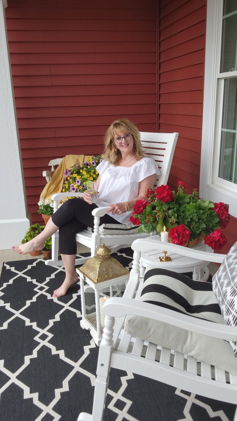 Lady sitting on a porch sitting in a rocking chair