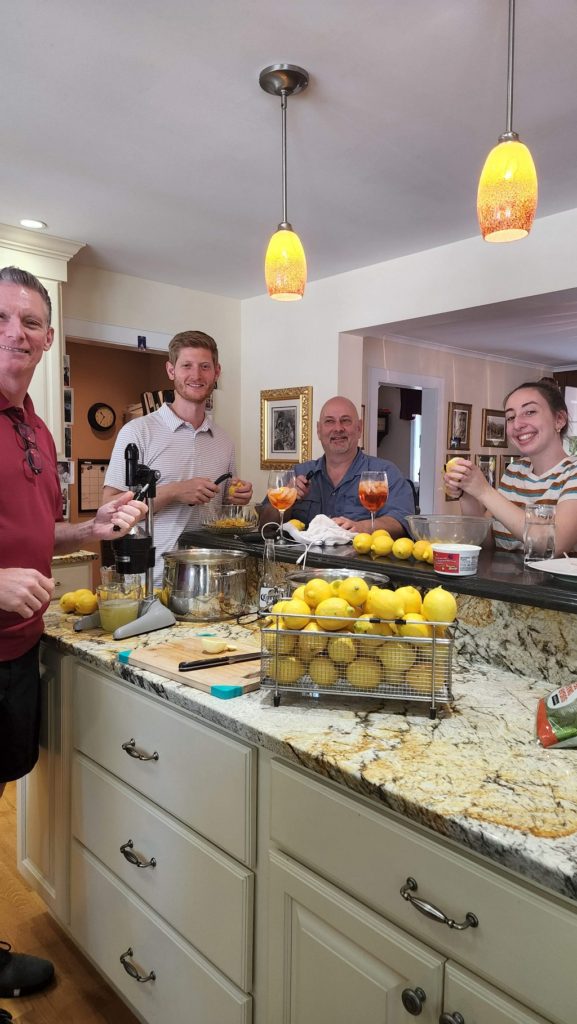 Family in kitchen peeling lemons