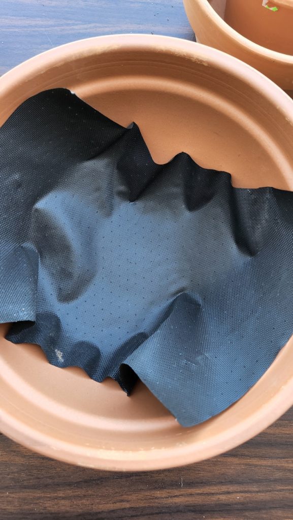 Black mesh in bottom of terra cotta pot