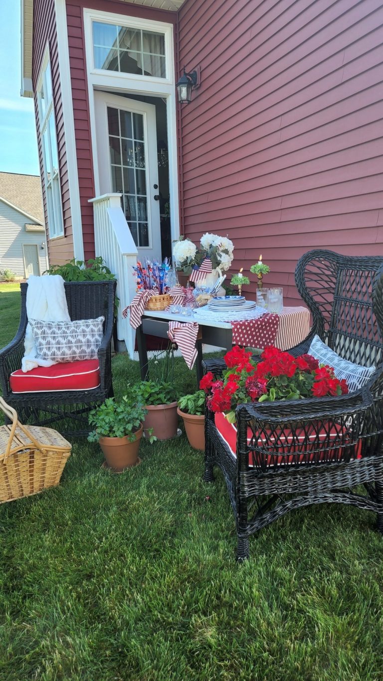 Black wicker chairs on lawn with flowers