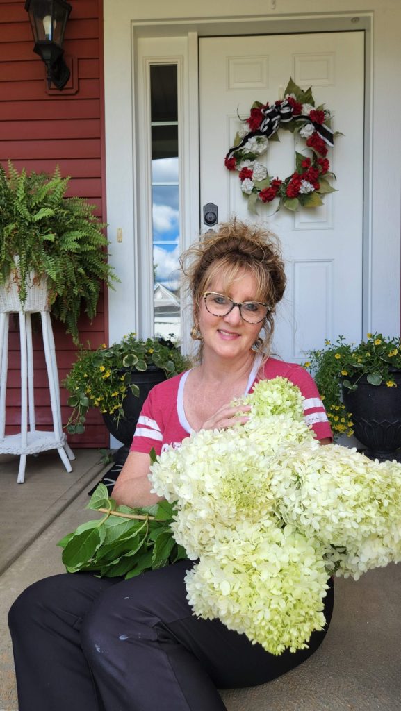 lady sitting on porch with hydrangeas in hand