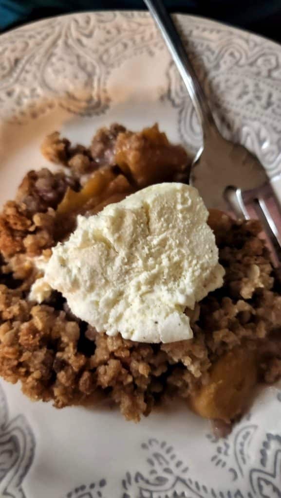 peach crisp on dish with ice cream