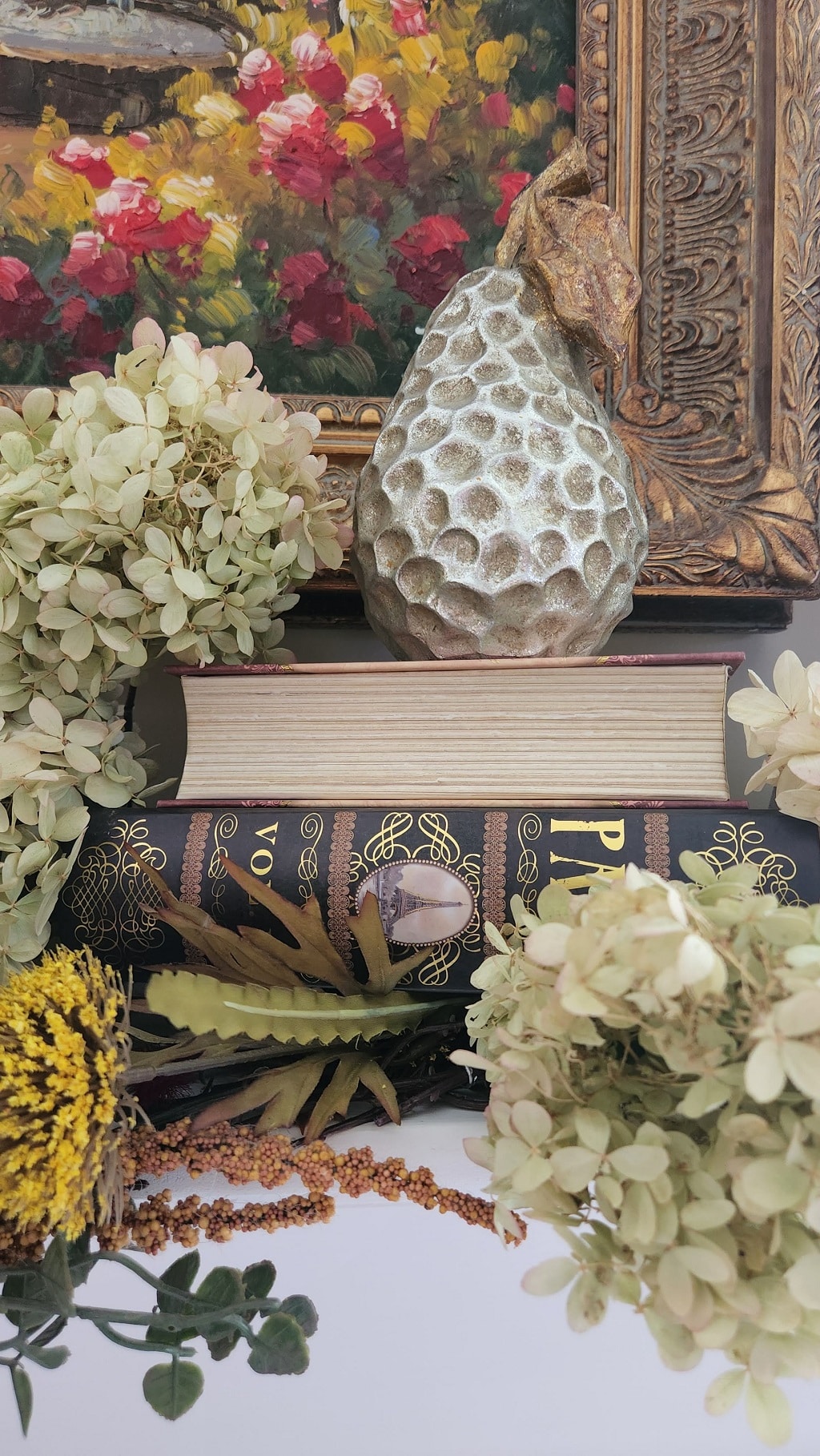 Books on mantel with faux pear