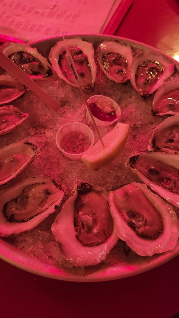 Dish of raw oysters with pink lighting