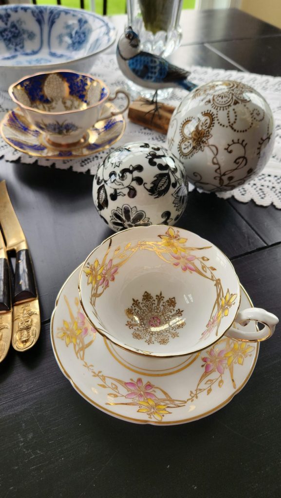 white and pale pink teacup on table