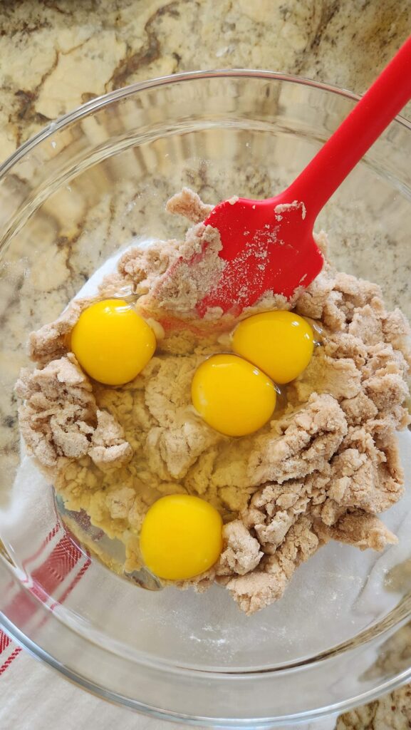 glass bowl with flour and eggs inside