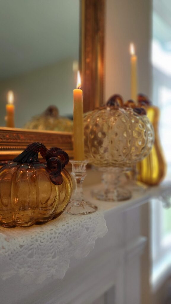 amber glass pumpkins on a mantel