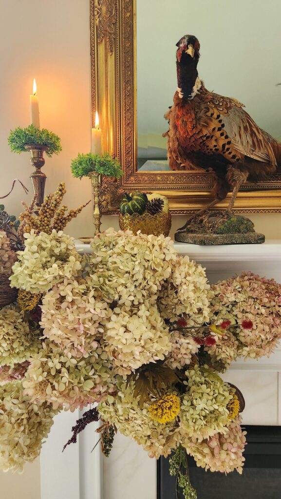 faux floral swag on mantle with stuffed pheasant
