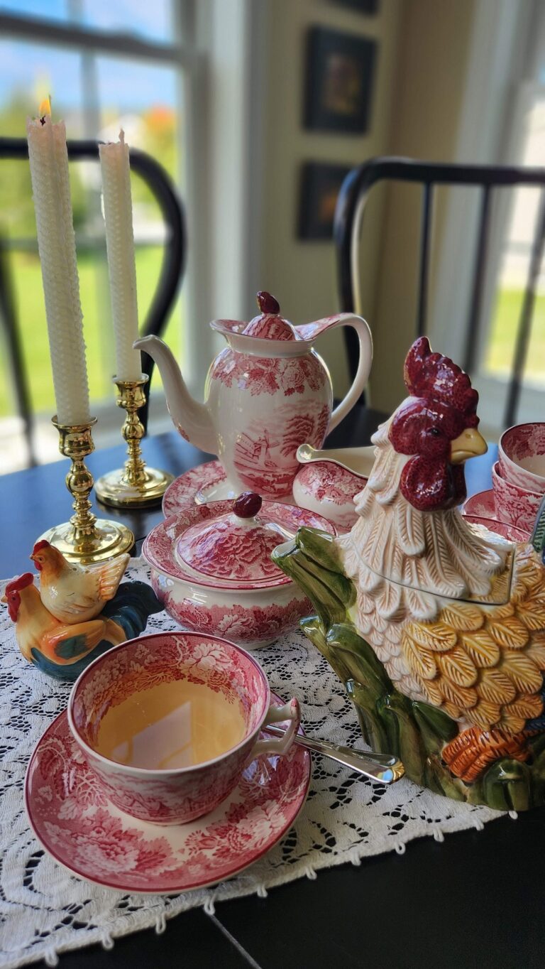 Rooster tea pot with red vintage dishes on table