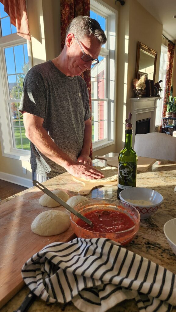 man making pizza on kitchen island