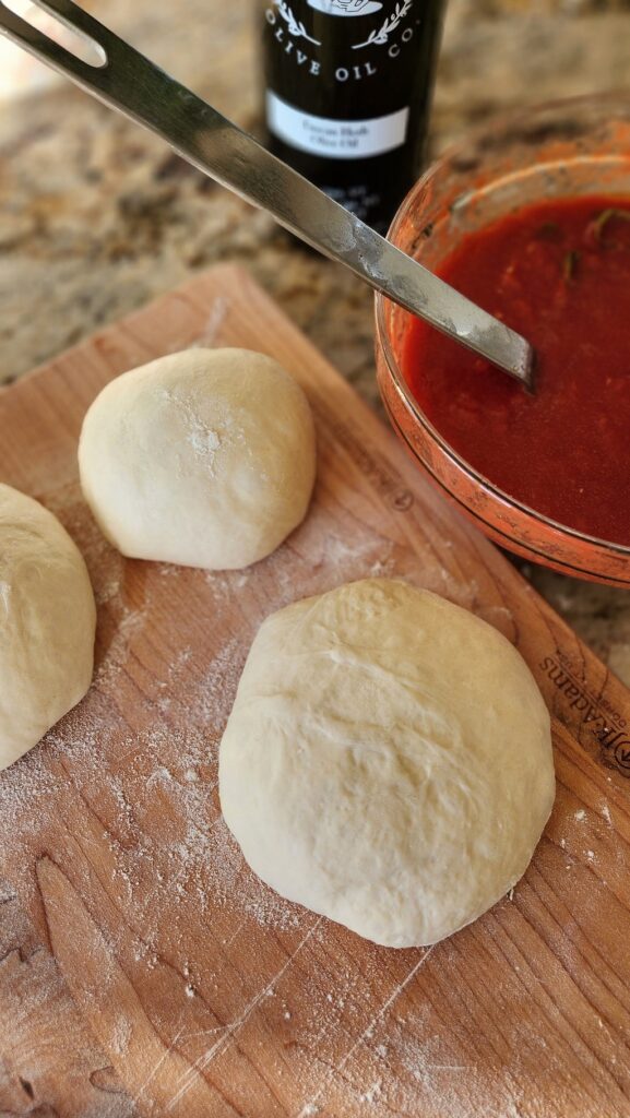 pizza sauce and pizza dough on counter