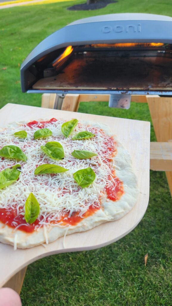 pizza on pizza peel going into ooni