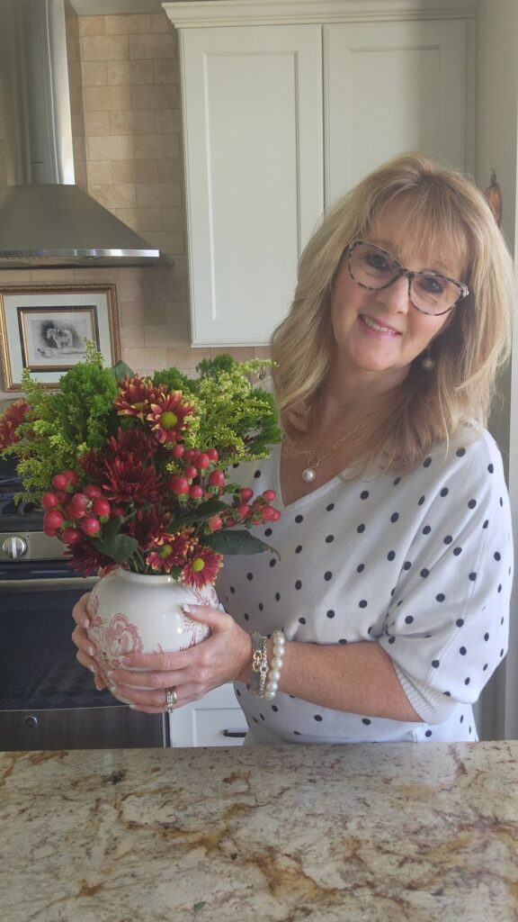 lady holding a ginger jar with flowers in it