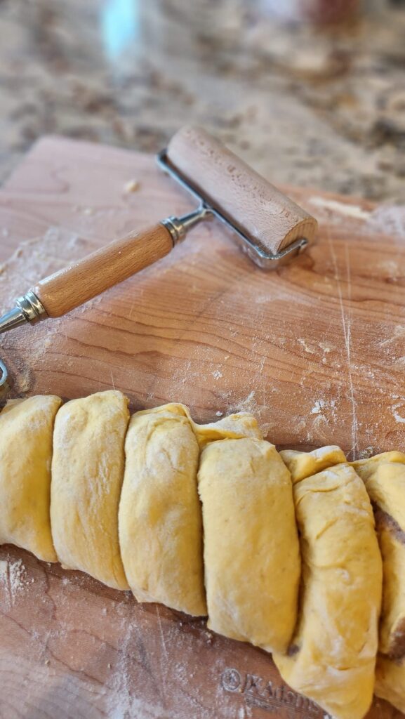 pumpkin bun roll being cut in 1 inch pieces