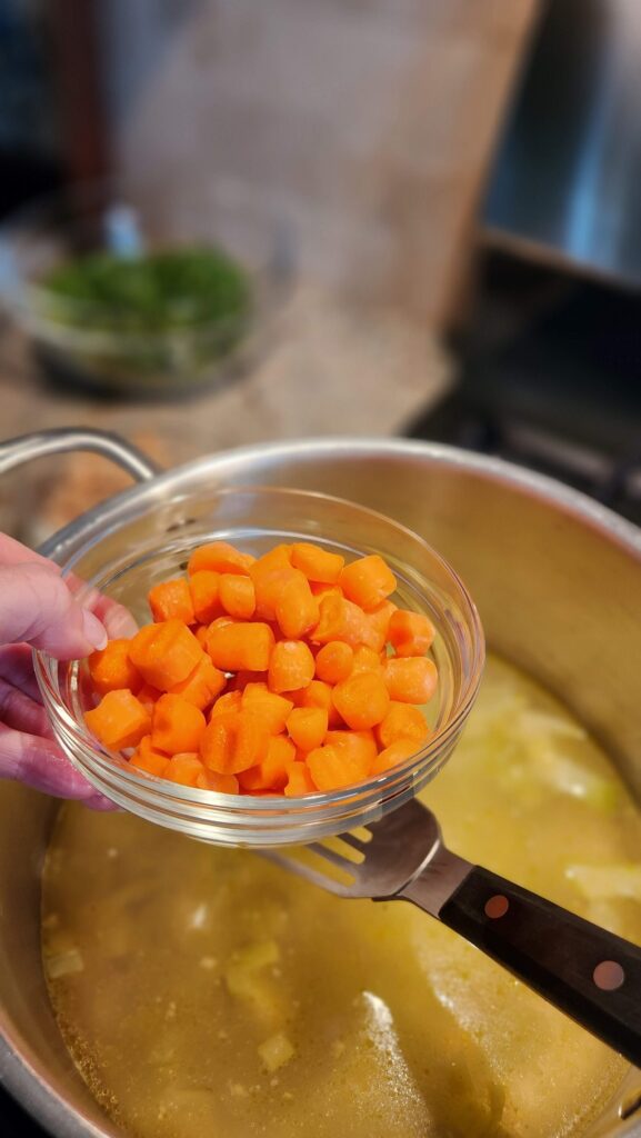 cup of cut up carrots ready to pour into pot