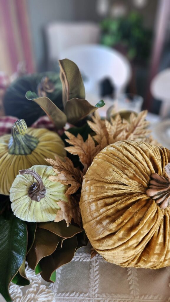 gold velvet pumpkin on table with other velvet pumpkins