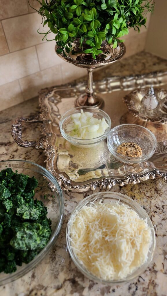 glass bowls on counter with spinach, onions and cheese in the them