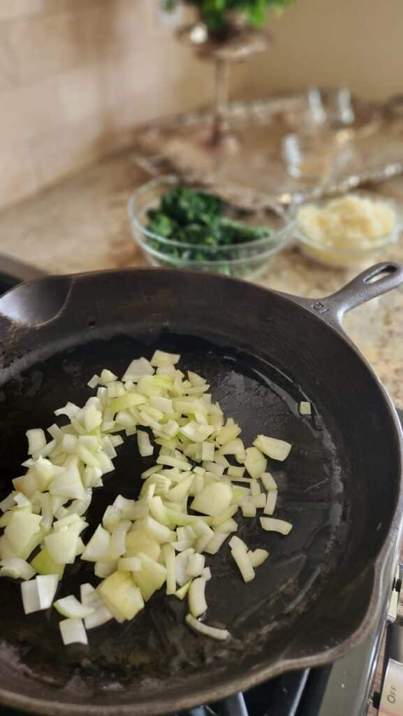 cast iron frying pan with onions sauteing