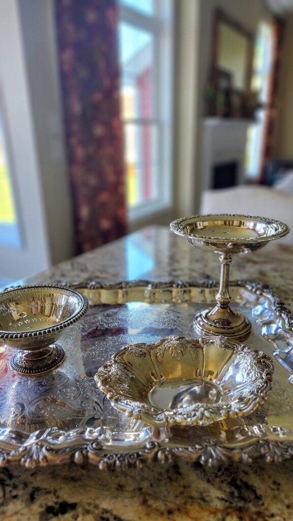 silver platter with silver pedestal dishes on counter