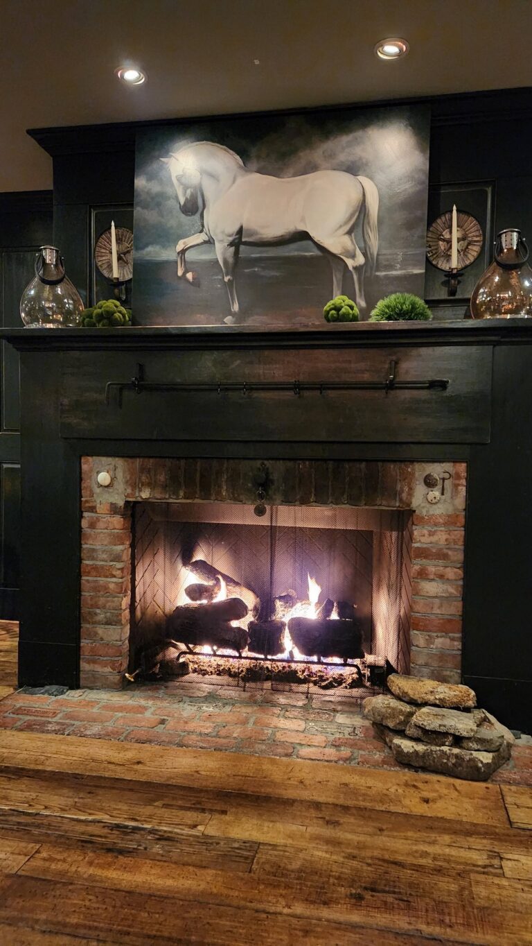 fireplace with horse painting over it