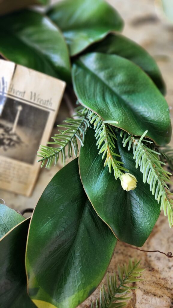 adding faux evergreen sprigs to wreath