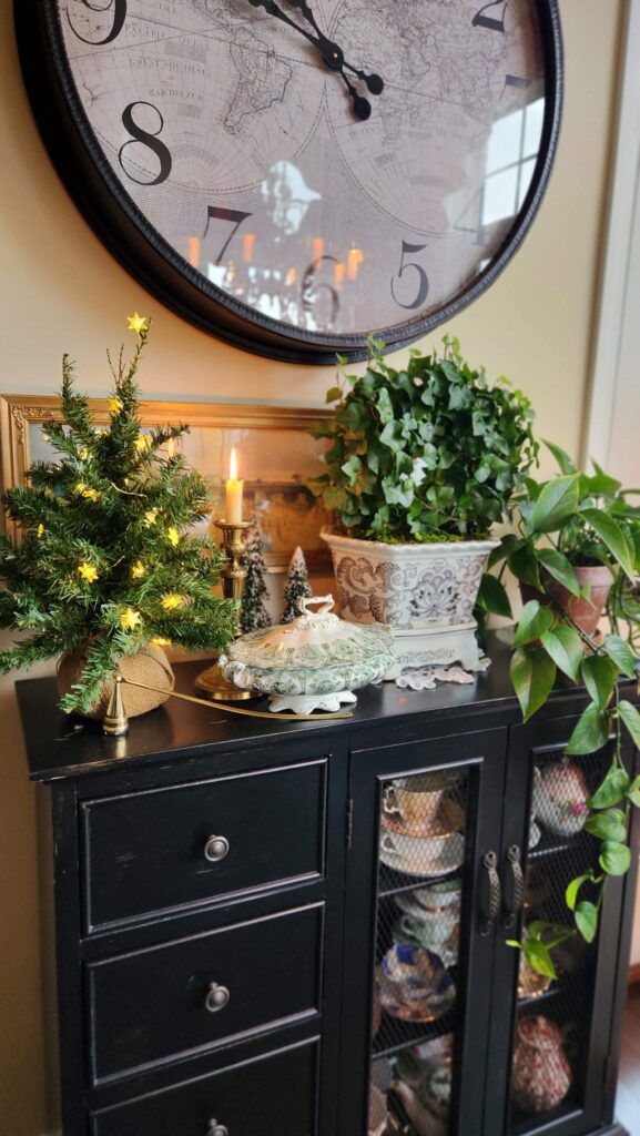 black sideboard table with green christmas tree and lights on top