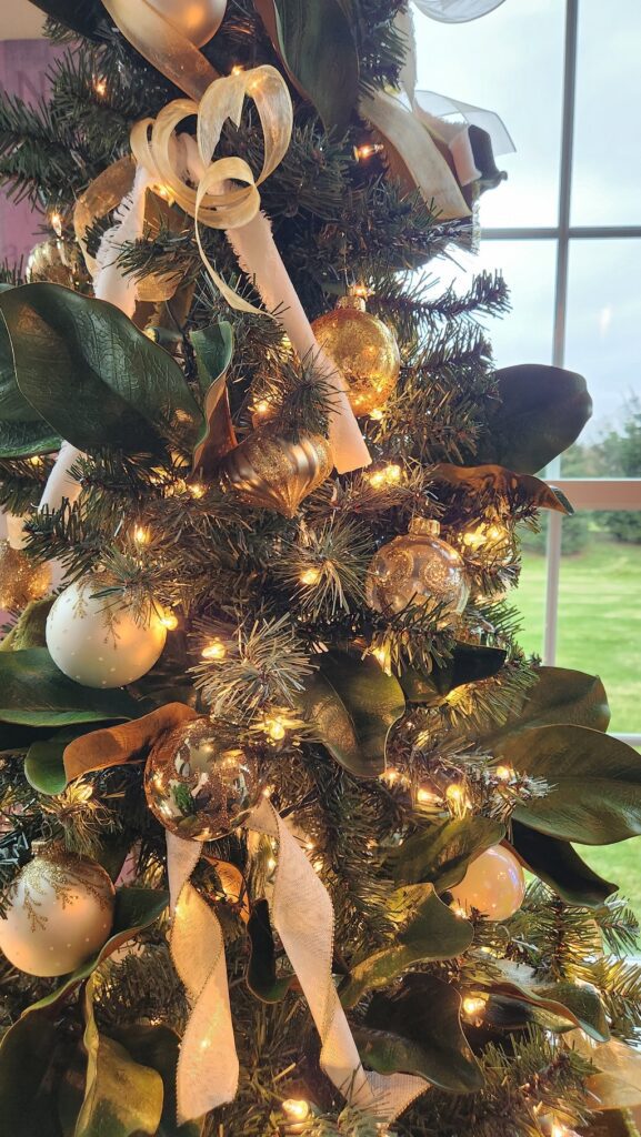 upclose of christmas tree with gold, ivory and green decorations