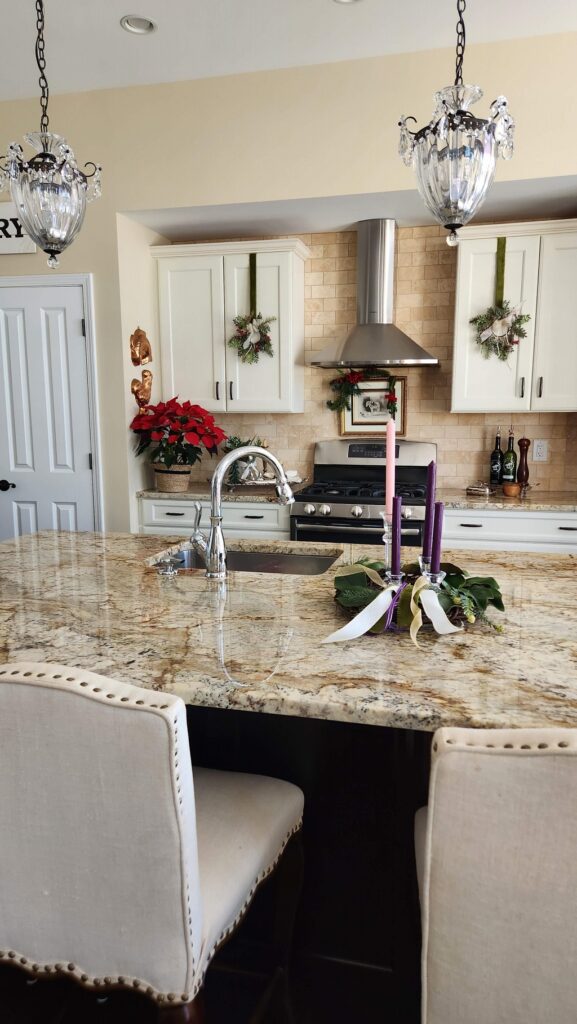 kitchen view of island and kitchen cabinets with christmas wreath hanging on door of cabinet